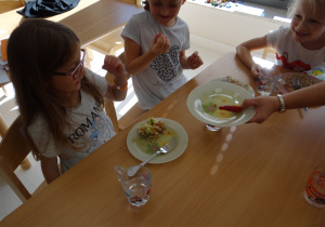 Oliwia, Nadia i Malika próbują papryki chili.